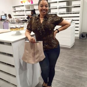 A curvy black lay holding a squeem package at a store